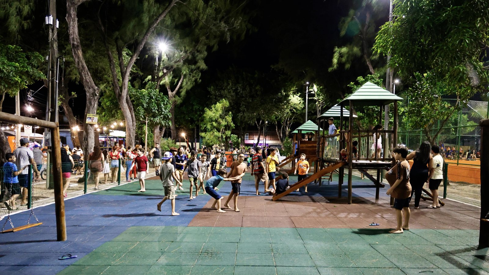 foto aberta da praça, mostrando crianças brincando num amplo pátio